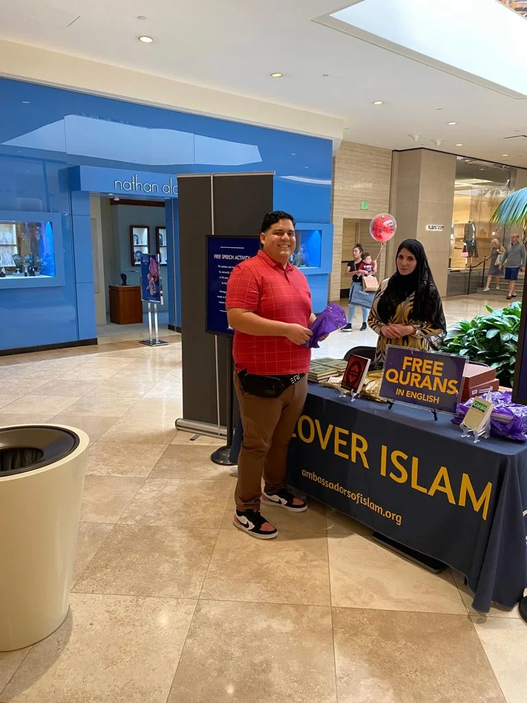 Ambassadors of Islam volunteers welcoming visitors at a community outreach table